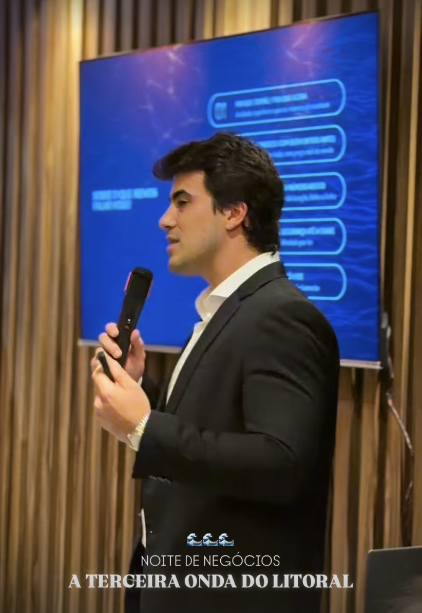Palestrante com microfone diante do telão em evento realizado no El Vinos Gastrowine